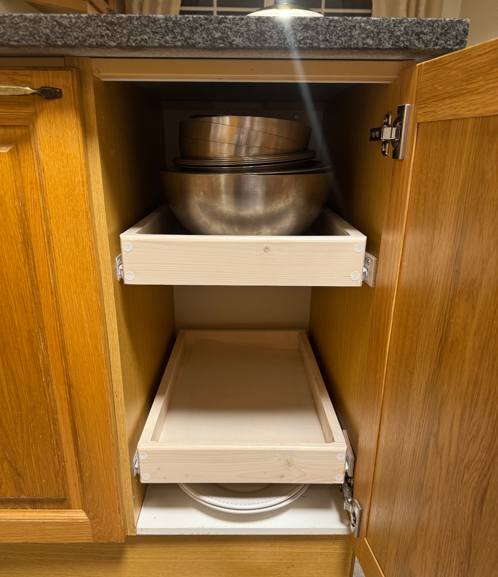 Kitchen cabinet with pull-out wooden drawers for pots, pans and plates