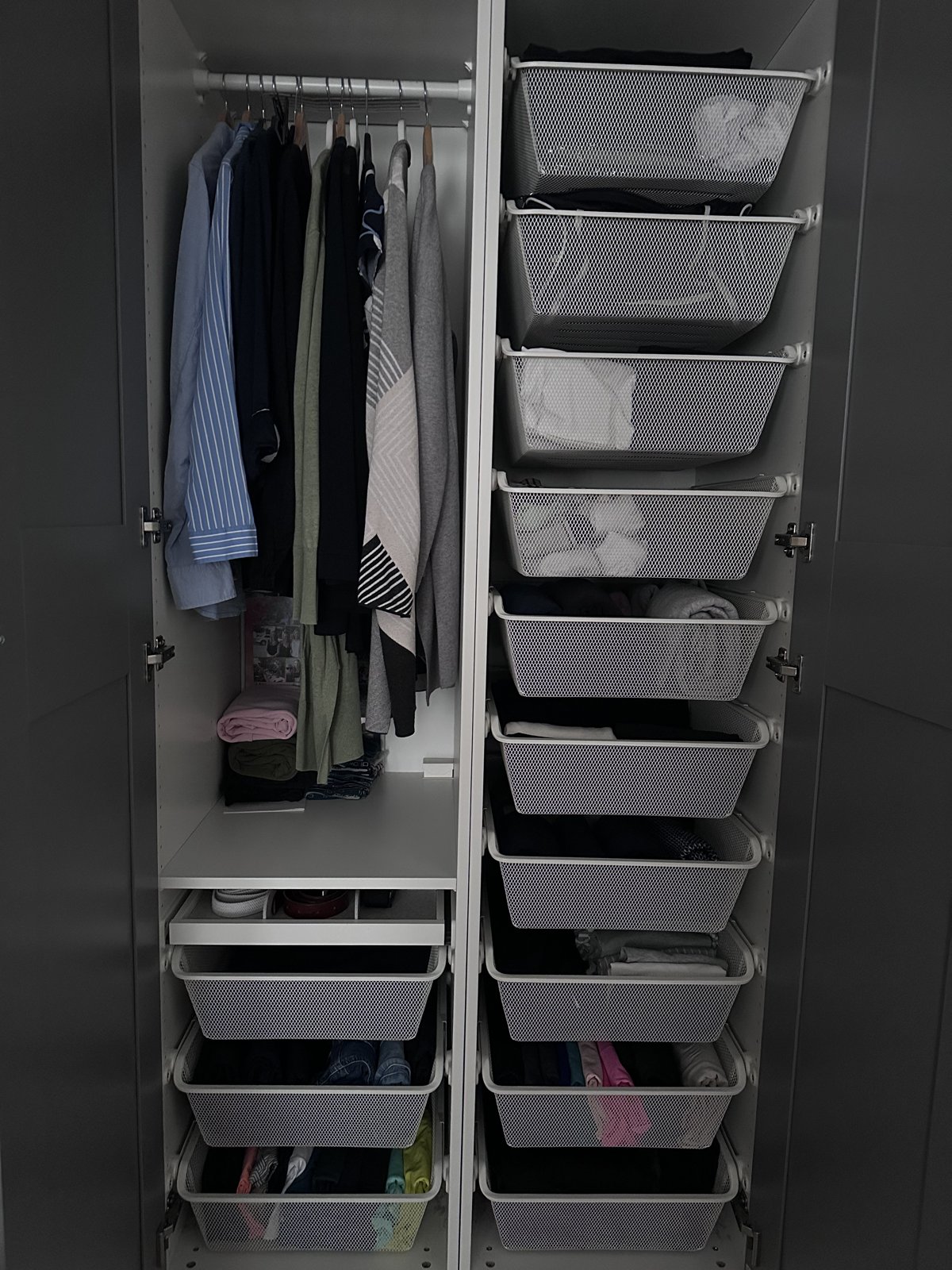 Wardrobe organised with hanging clothes and labelled mesh basket drawers for easy resets