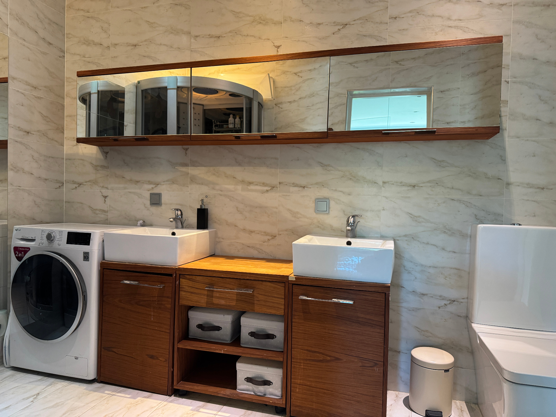 Bathroom with double sinks, wooden vanity and organised storage baskets